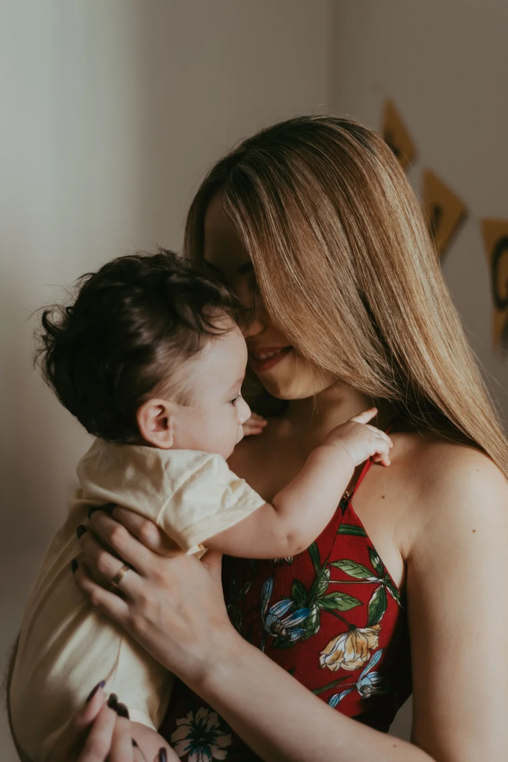 Eine Mutter lächelt ihr Baby an und hält es nah bei sich